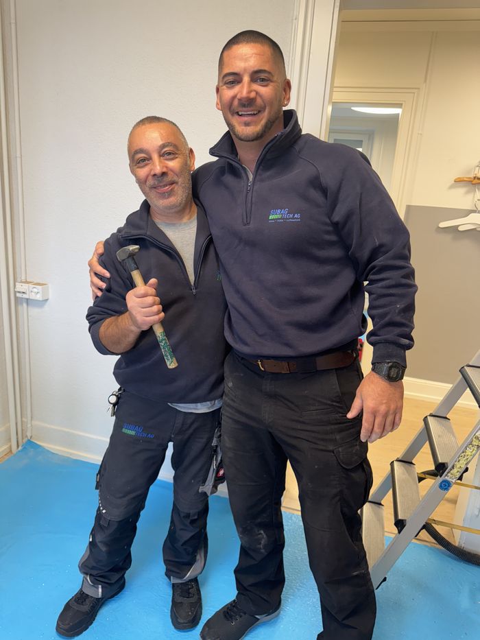 Zwei Servicetechniker freuen sich über die spannende Installation.