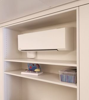 Bei der Installation integriertes Klimagerät in ein Regal beim DoktorHaus Fislisbach